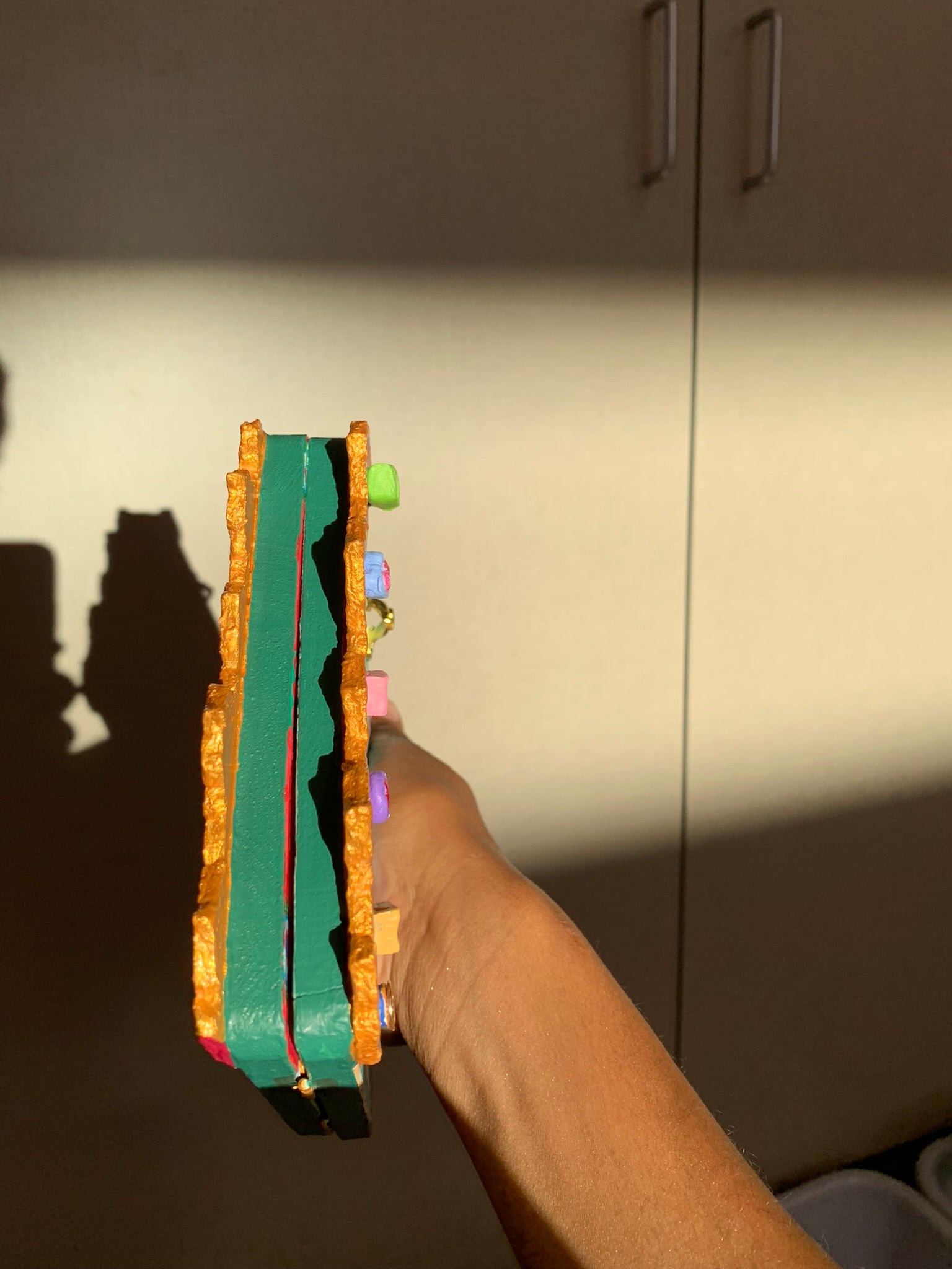 Holding a Colorful carousel-themed artwork showing the upper dimension details. The Miraculous Carousel Girls wooden painting book, vibrantart, equineart, carouselride, merrygoroundmagic, immersiveart, nostalgickidcore, hopefulart, innocentjoy, nurserydecor, babygirlroom, childlikemagic, playfulimagination, joyfulplaytime, majesticlookbook, nurserybabyart, babygirldecor, cherishablekeepsakes, functionalsurrealism, surrealismsculpture