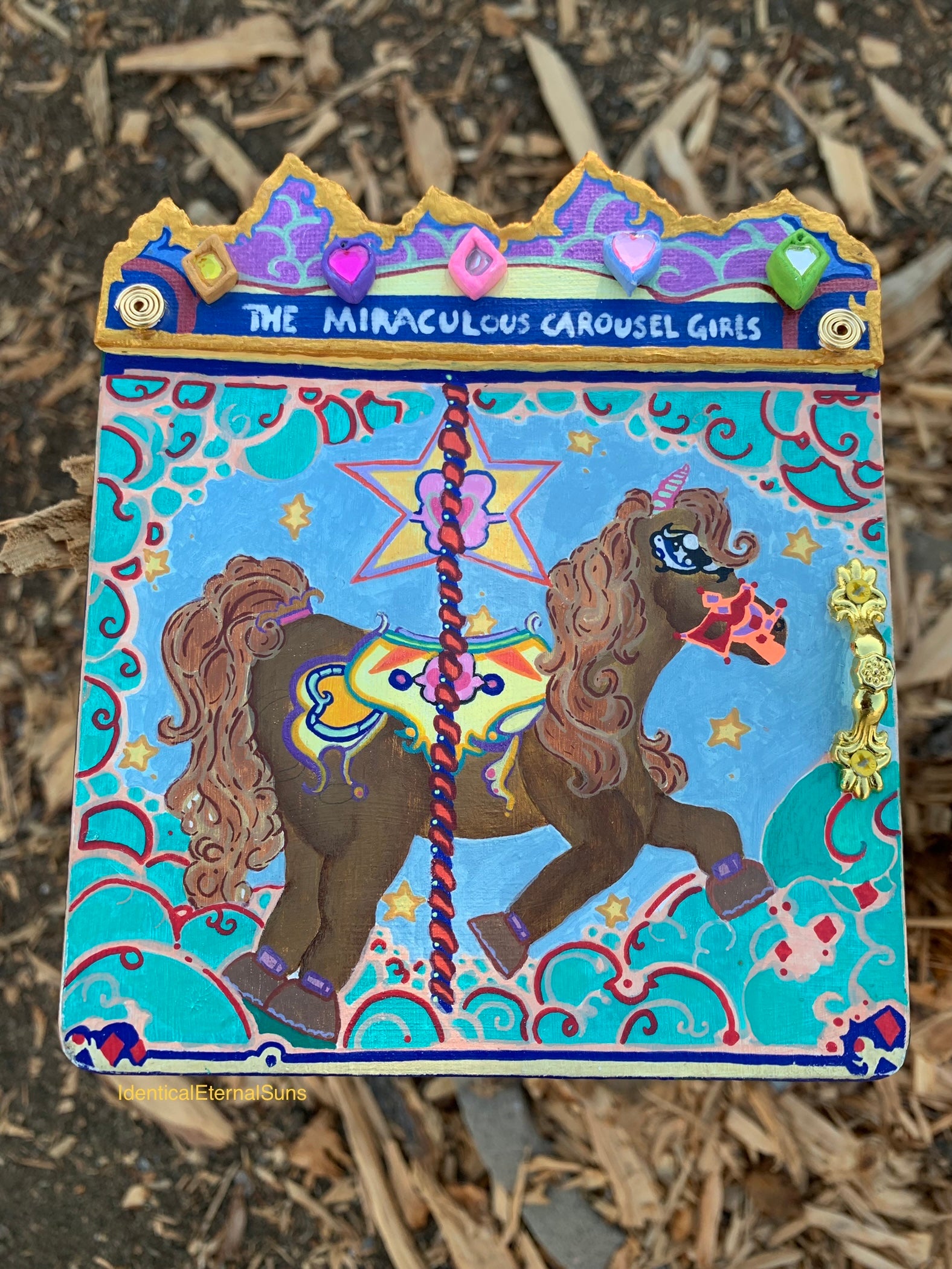 Colorful artwork of a carousel horse with decorative elements on a textured surface. Colorful carousel-themed pony mini painting artwork. The Miraculous Carousel Girls wooden painting book, vibrantart, equineart, carouselride, merrygoroundmagic, immersiveart, nostalgickidcore, hopefulart, innocentjoy, nurserydecor, babygirlroom, childlikemagic, playfulimagination, joyfulplaytime, majesticlookbook, nurserybabyart, babygirldecor, cherishablekeepsakes, functionalsurrealism, surrealismsculpture